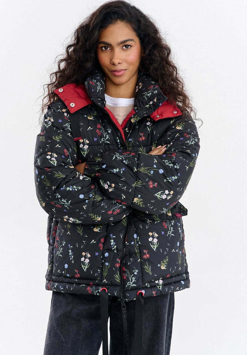 Pikowana kwiecista kurtka w kolorze czarnym z czerwonym kołnierzem, posiadająca sznurek ściągający u dołu, wielokolorowe wzory kwiatowe oraz zamek błyskawiczny.