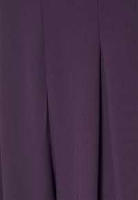 Tela morada con una textura suave y un sutil brillo, que presenta un detalle de pliegue vertical a lo largo del costado para un interés de diseño añadido.