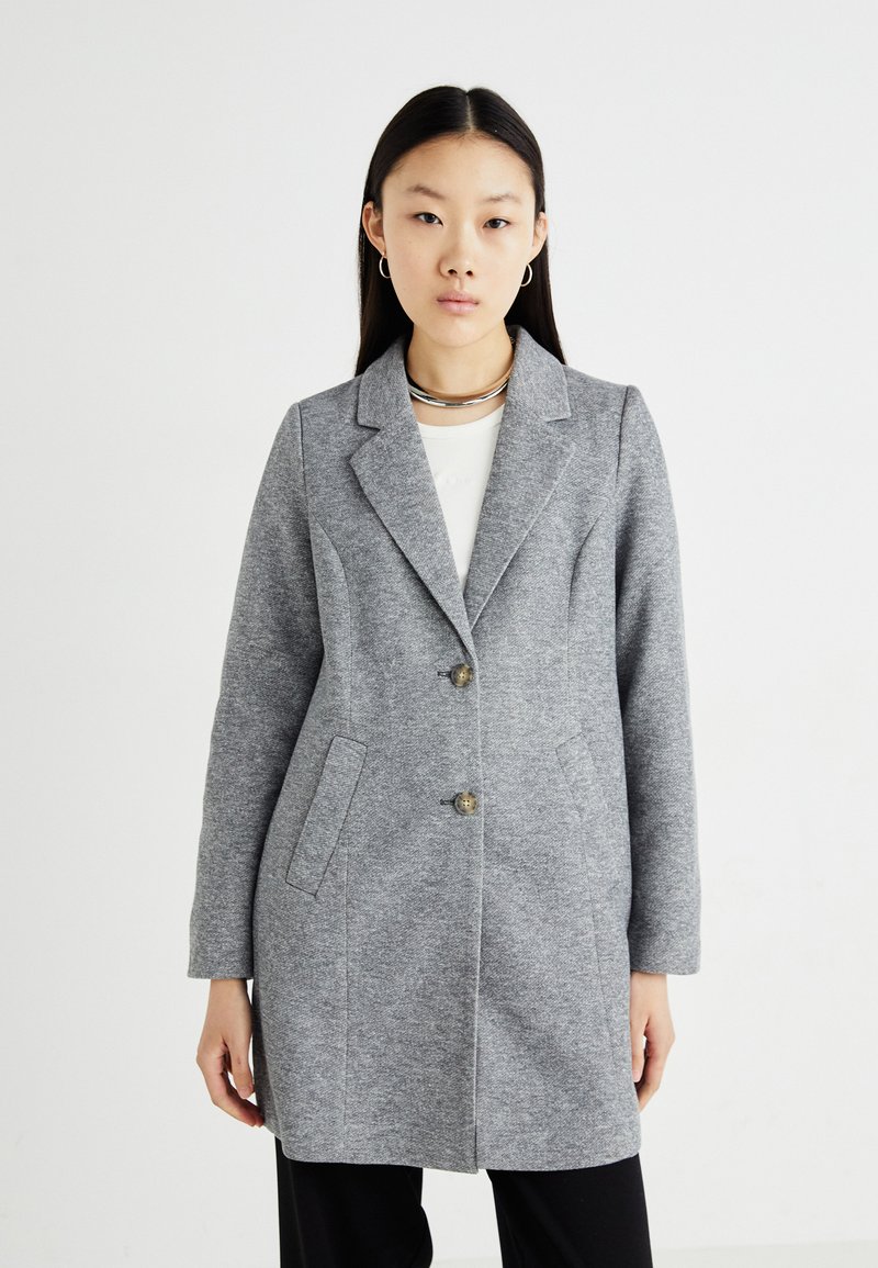 Manteau en mélange de laine grise au design ajusté, avec revers à cran, fermeture à deux boutons et poches latérales. Texture lisse et coupe mi-longue.