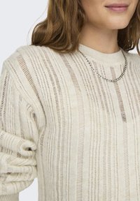 Lekki sweter dziany w kolorze ecru z poziomymi paskami, z teksturowanym wzorem i wąskim prążkowaniem wokół okrągłego dekoltu.