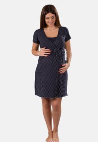 Vestito da allattamento nero con pois bianchi, maniche corte, scollatura a V e laccio regolabile sul lato, realizzato in un tessuto morbido ed elastico.