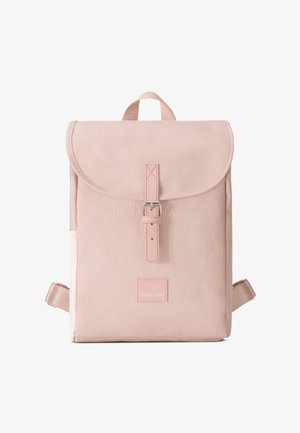 Light pink fabric backpack with a flap closure, buckle detail, and adjustable straps. Features a brand patch on the front. Textured surface.