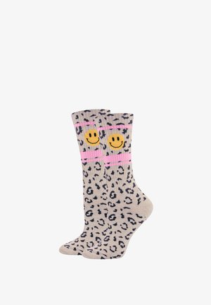 Leopard-print socks in beige with black spots, featuring a pink band and two yellow smiley faces on the cuffs. Soft fabric, mid-calf length.