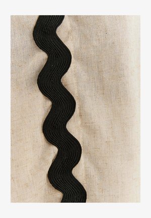 Naturalna tkanina lniana z fakturowanym, falistym czarnym wykończeniem wzdłuż jednego boku, podkreślająca kontrast i detale.