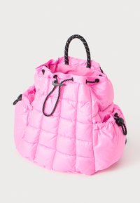 Rožinė emaliuota maišelio su styginiu užsegimu maišelis su juoda ir balta virvele ir reguliuojamomis šoninėmis kišenėmis ant vientiso fono.