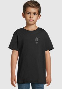T-shirt en coton noir avec un graphique blanc représentant un ballon de basket et une main sur le devant. Manches courtes et encolure ras du cou classique.