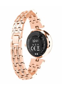 Montre en métal rose gold avec un bracelet en maillons, embellie de petits cristaux, et un cadran rond noir affichant le logo de la marque et des symboles.