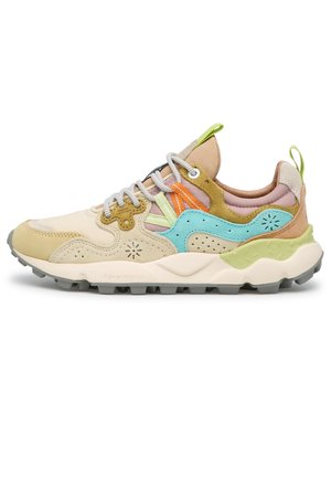 Baskets multicolores avec des panneaux en daim beige, bleu et vert, lacets blancs, semelle extérieure grise, et languettes de traction sur la languette et le talon.