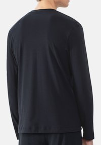 Langsleeve shirt in donker marineblauw katoen, met een ronde hals, rechte zoom en een gladde textuur. Minimalistisch ontwerp zonder versieringen.