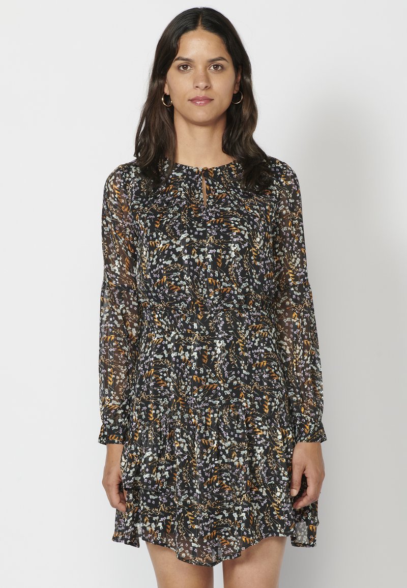 Schwarzes Langarm-Kleid mit Blumenmuster und gestuftem Rock, das ein überall vorhandenes Muster mit weißen, orangen und grünen Akzenten aufweist und aus einem transparenten Stoff gefertigt ist.