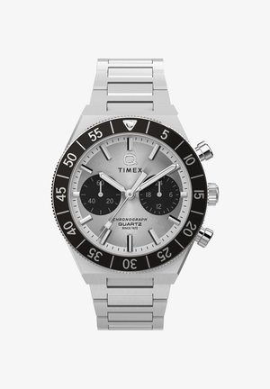 Ceas cronograf Timex argintiu cu beză neagră, două cadrane subțiri negre, marcaje orare argintii și brățară din lănțișoare metalice.