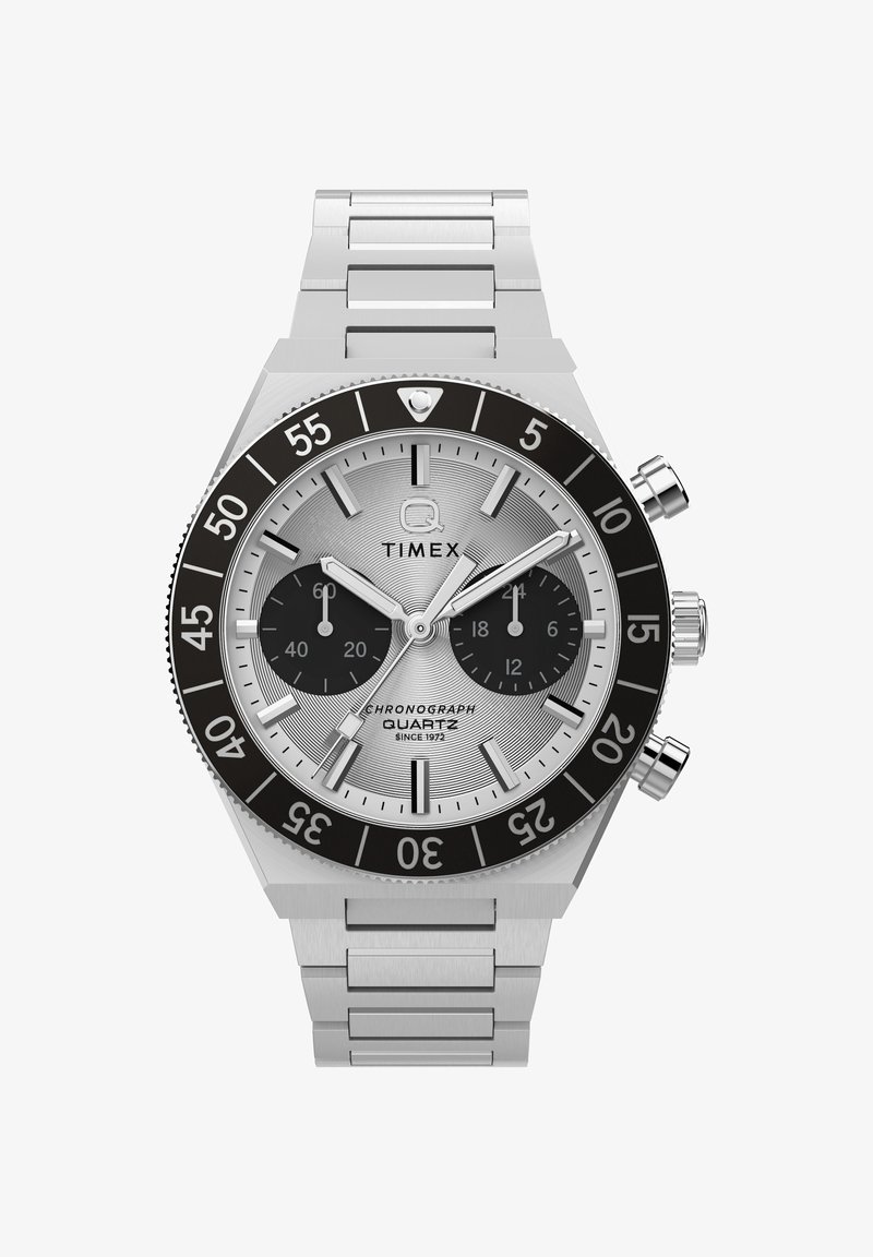 Montre chronographe Timex argentée avec lunette noire, deux sous-cadrans noirs, index des heures argentés et bracelet à maillons métalliques.