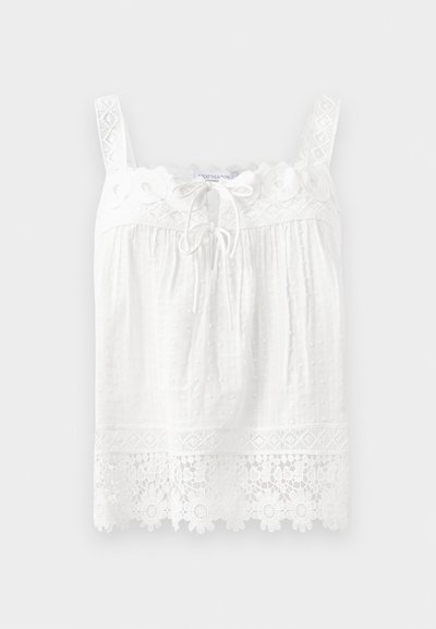 White sleeveless top made of textured fabric. Features a lace trim at the neckline and hem, with floral embroidery and a drawstring front.