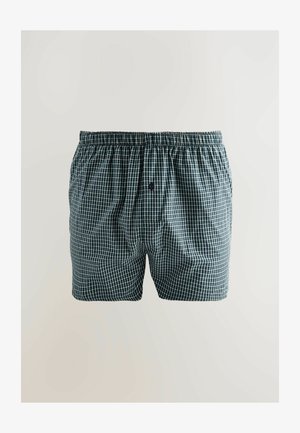 Sötétzöld és fehér kockás mintás boxer short, szőtt anyagból készült. Rugalmas derékkal és elöl gombos záródással rendelkezik.