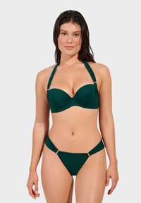 Green bikini with a structured strapless top and adjustable halter straps, featuring gold hardware accents and a low-rise bottom.