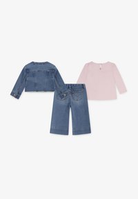 Jeansjacka i kort modell, ljusrosa långärmad topp och vida jeansbyxor. Funktioner inkluderar knappar, fickor och en nyckelhålsöppning bak.