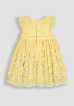 Gul kjole med flæseærmer, broderede blomster mønstre i hvid og blå, knaplukning bagpå, og en sammensynket nederdel.