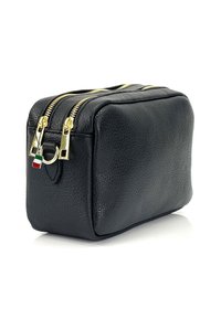 Schwarze Leder-Handtasche in rechteckiger Form mit einer strukturierten Oberfläche, zwei goldenen Reißverschlüssen und einem goldfarbenen Hardware-Element, das eine kleine italienische Flagge zeigt.