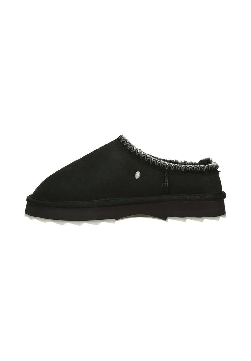 Zapatos negros sin cordones hechos de suave ante con un forro blanco texturizado, que cuentan con un borde de costura contrastante y una suela gruesa y resistente.