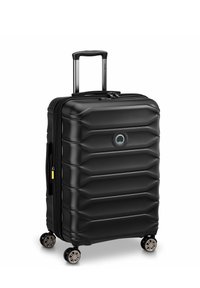 Schwarzer Hartschalenkoffer mit gerippter Oberfläche, ausziehbarem Griff und vier drehbaren Rollen. Metallische Akzente an den Rollen. Reißverschlussverschluss.