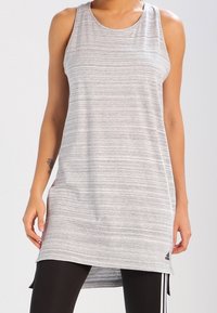 Tunic atletico senza maniche a righe grigie con scollatura rotonda, parte posteriore più lunga e logo Adidas sull'anca. Realizzato in tessuto leggero.