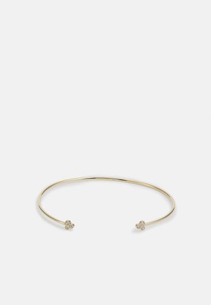 Bracelet jonc fin en or ouvert avec trois petits cristaux ronds regroupés à chaque extrémité sur fond blanc uni.