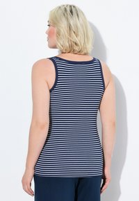Canotta a righe blu navy e bianca con scollatura tonda e spallini sottili, caratterizzata da un design aderente che mette in evidenza la forma.