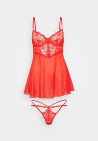 Set de lingerie en dentelle rouge et mesh, comprenant un bustier à bonnets avec un ourlet évasé et des fines bretelles réglables, accompagné d'un string assorti.