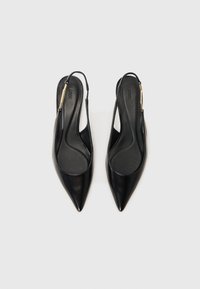 Escarpins en cuir noir à lanière avec bouts pointus, surface lisse, bride de cheville et accent doré sur le talon. Convient pour les tenues formelles.