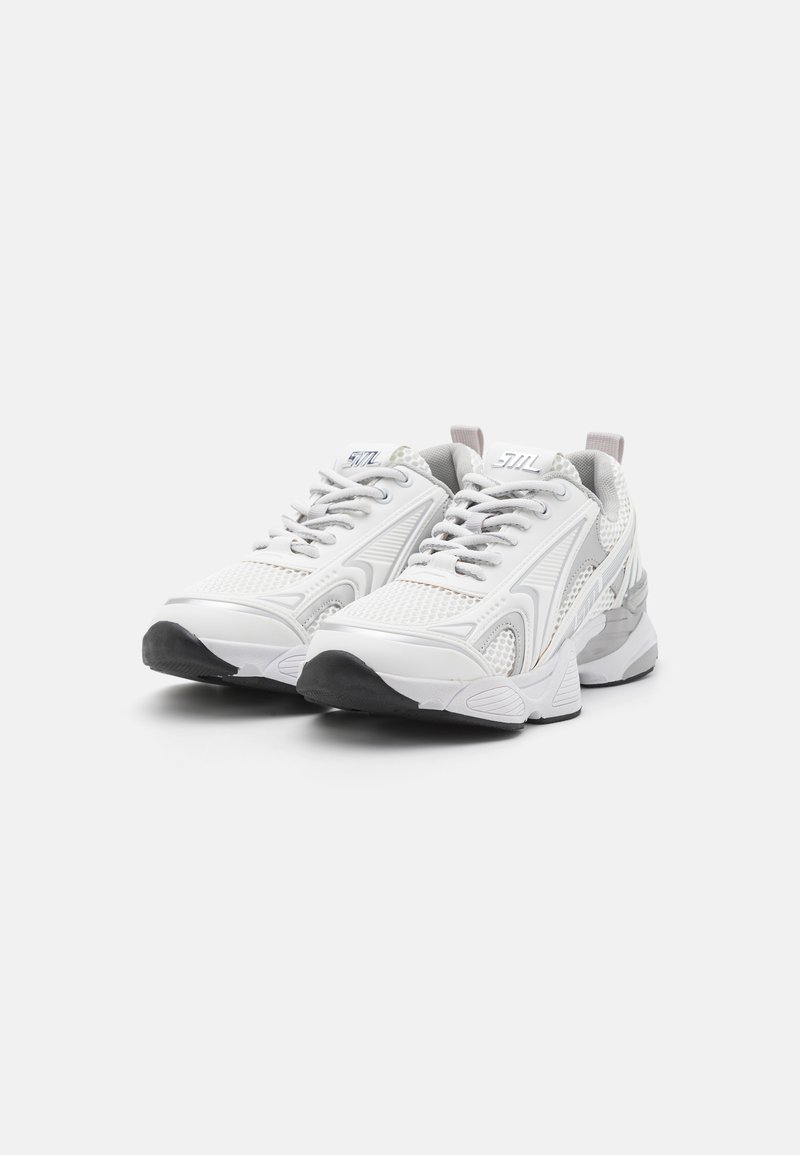 Witte sportieve schoenen met mesh- en synthetische panelen, gestructureerde zolen en lichtgrijze accenten. Voorzien van een ronde neus, veters en branding.