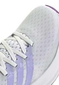 White mesh athletic shoe with lavender accents, textured upper, flat white laces, and a rubber sole featuring a ribbed pattern.