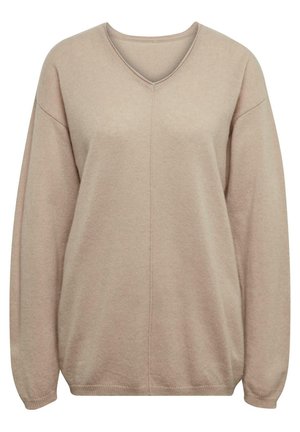 Pull beige en V en tissu doux et texturé, avec des épaules tombantes et des poignets côtelés, mettant en avant un détail de couture central.