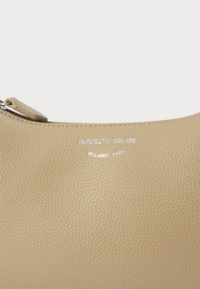 Μπεζ δερμάτινη τσάντα με υφή, διακοσμημένη με ασημένια εγχάρακτη επιγραφή: «EMPORIO ARMANI MILANO 1931» και φερμουάρ κλεισίματος.