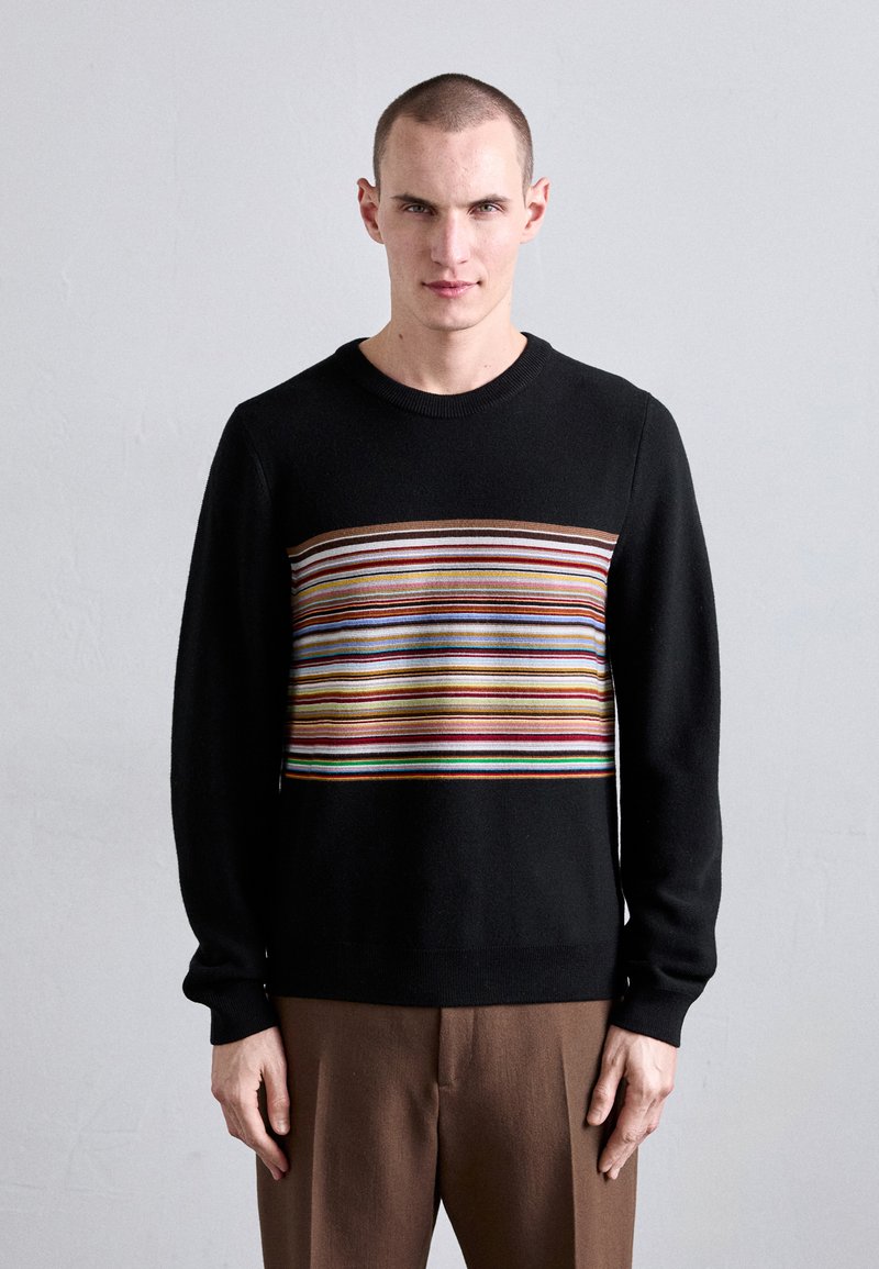 Black sweater with a horizontal striped pattern in various colors across the chest. Features a round neck and long sleeves.