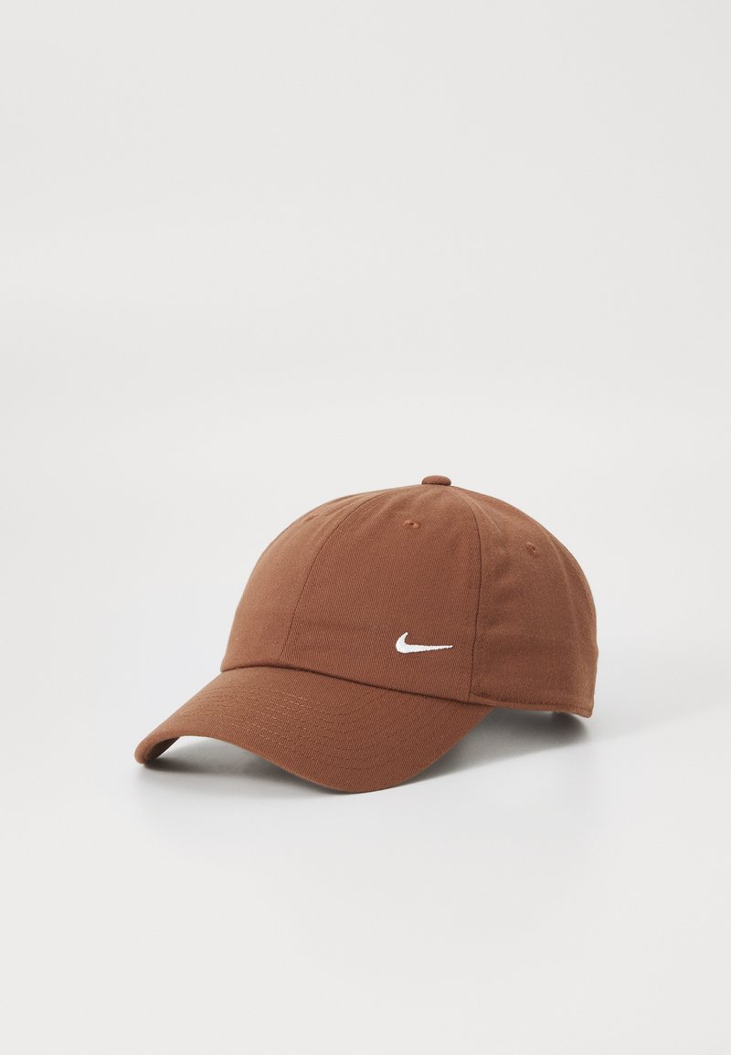 Boné de baseball em algodão marrom com uma coroa arredondada e uma aba curva. Apresenta um logótipo da Nike branco na frente. Design simples e de tecido texturizado.