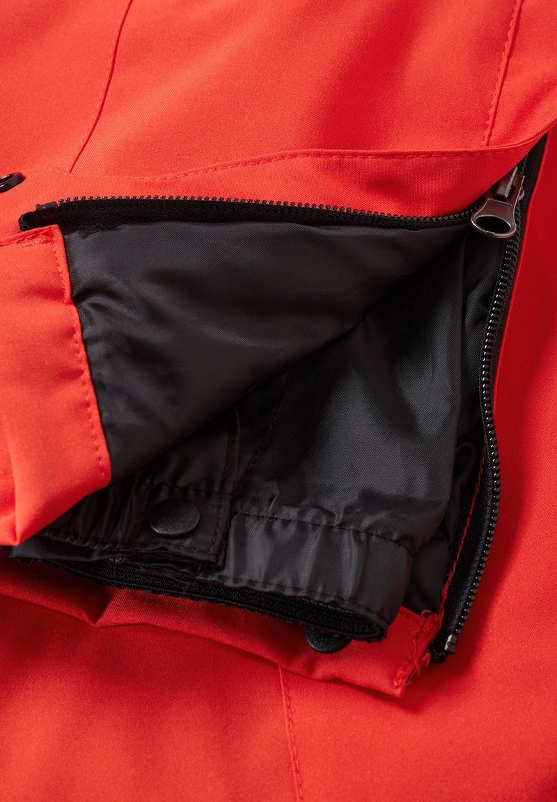 Rote Jacke aus einem glatten Stoff, ausgestattet mit schwarzem Futter und Reißverschlüssen. Enthält Druckknöpfe und eine Innentasche.