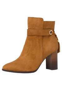 Stivaletto in suede beige con tacco a blocco, dettaglio con cinturino attorno alla caviglia e accentuato da un pon-pon sul retro.