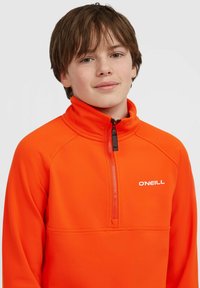 Oranje fleece pullover met een half-zip kraag, voorzien van een wit logo op de borst en een gladde, gestructureerde stof.