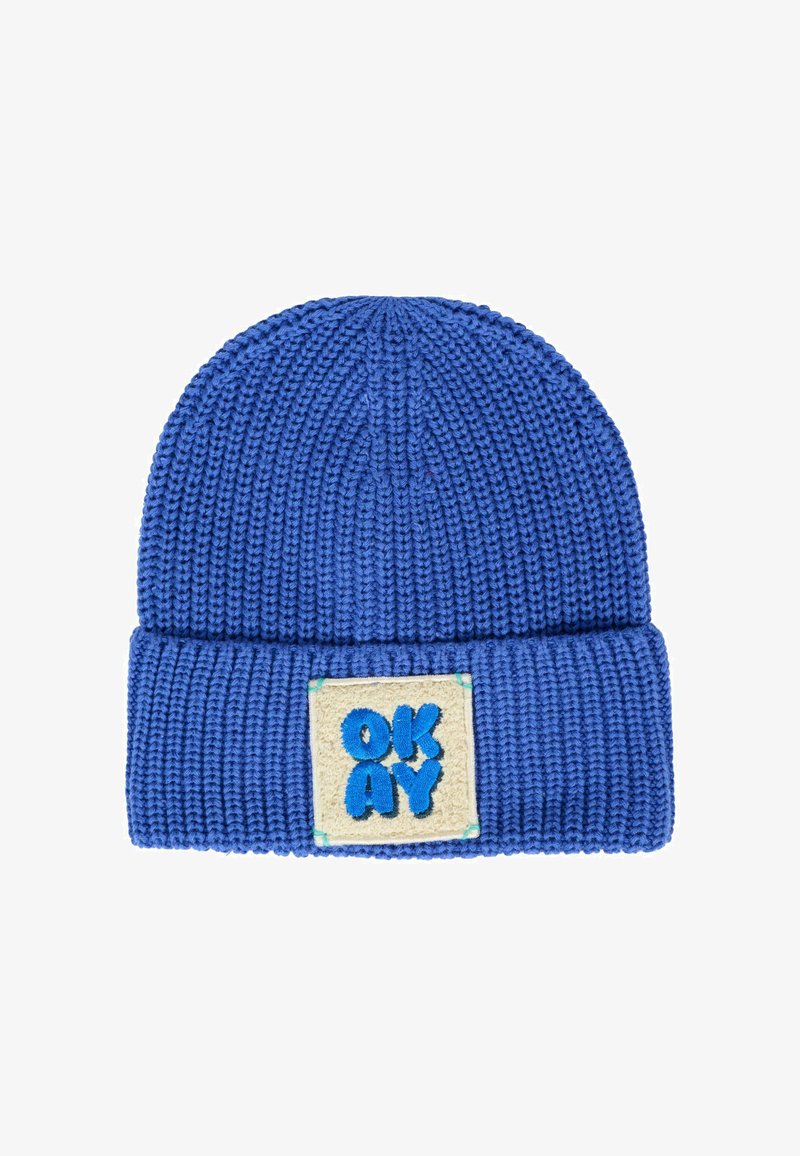 Blauwe gebreide muts met omgeslagen rand, voorzien van een crèmekleurig patch geborduurd met het woord "OKAY" in grote blauwe letters.