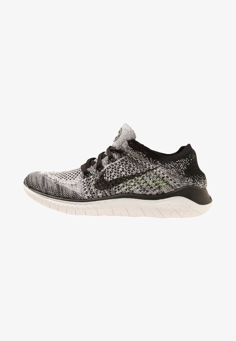 Chaussure de sport en maille noire et grise avec lacets noirs et semelle blanche, présentée de profil vers la gauche.