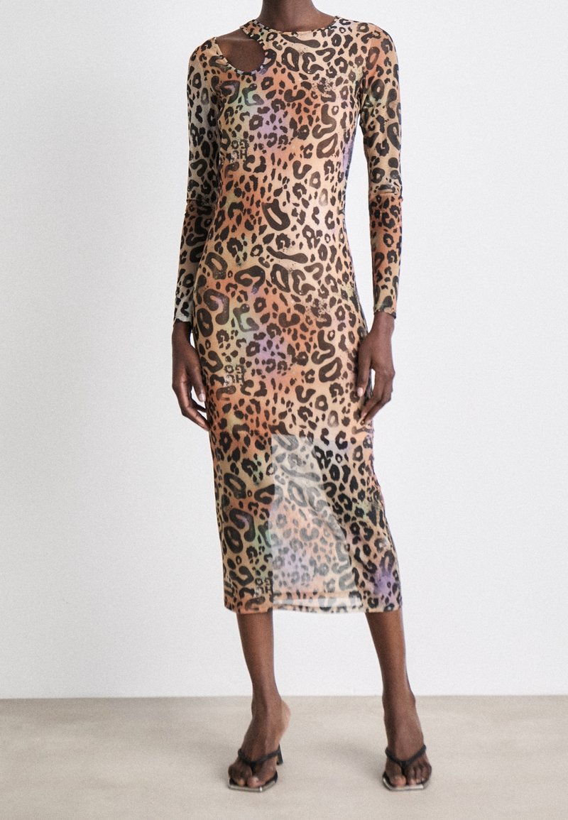 Robe ajustée à manches longues en tissu transparent à imprimé léopard, avec une découpe distinctive à l'épaule et une longueur midi.