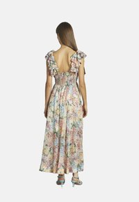 Blumenkleid im Maxistil mit Rüschenträgern, offenem Rücken und gerafftem Oberteil. Merkmale sind pastellfarbene Töne und ein fließendes Design, perfekt für wärmeres Wetter.