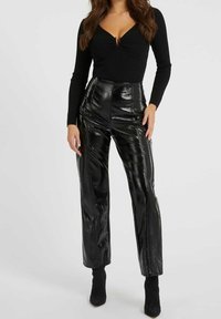 Czarne spodnie z wysokim stanem wykonane ze skóry ekologicznej o błyszczącym wykończeniu, z przeszyciami i prostą nogawką.