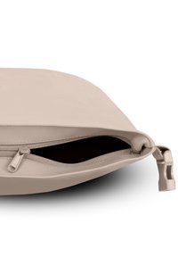 Pungă de culoare bej deschis, realizată dintr-un material neted. Dispune de o deschidere cu fermoar și un interior întunecat, precum și de un tirbușon mic pe lateral.