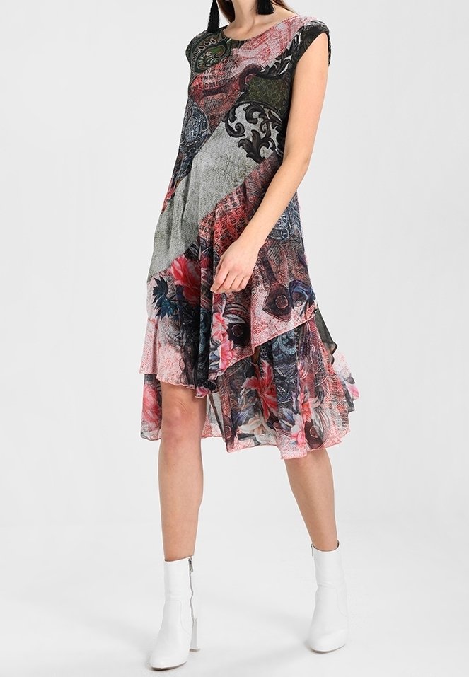 Robe multicolore avec un design en couches présentant des motifs floraux et géométriques, manches courtes et ourlet fluide.