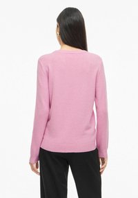 Rozā adīts džemperis no mīksta materiāla, ar garām piedurknēm, apaļu izgriezumu un ribotu apakšmalu. Piemērots ikdienas valkāšanai.