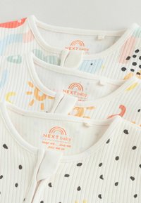 Drei übereinander gestapelte Babybekleidungsstücke aus weichem Baumwollstoff mit bunten Mustern: Streifen, Punkte und Sonnenmotive; gerippte Textur und Druckknöpfe.