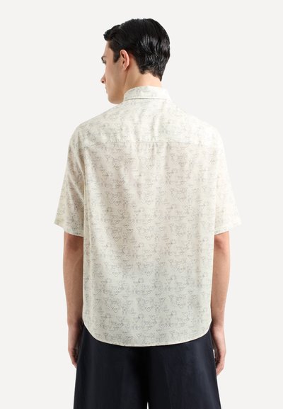 Camicia a maniche corte in tessuto crema chiaro, presenta un motivo ripetuto discreto, colletto e orlo dritto, progettata per un fit comodo.