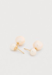 Boucles d'oreilles en or avec une pierre rose clair texturée et irrégulière, et une sphère blanche lisse à la base, au design minimaliste.