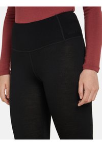 Svarta leggings gjorda av lätt och stretchigt material. Har ett brett, hög midja och synliga sömmar, vilket ger en smidig silhuett.